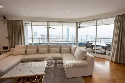Luxurious living room with panoramic city view and spacious balcony in modern apartment.