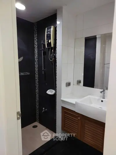 Modern bathroom with sleek shower and stylish vanity in contemporary apartment.