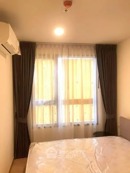 Cozy bedroom with natural light and modern air conditioning unit.