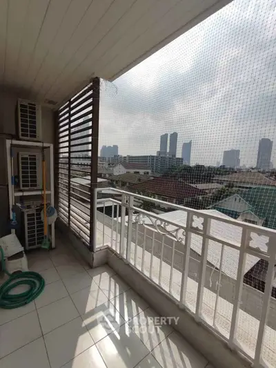 Spacious balcony with city skyline view, perfect for relaxation and enjoying urban living.