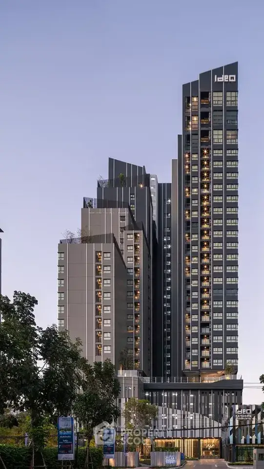 Stunning modern high-rise building with sleek design and illuminated windows at dusk.