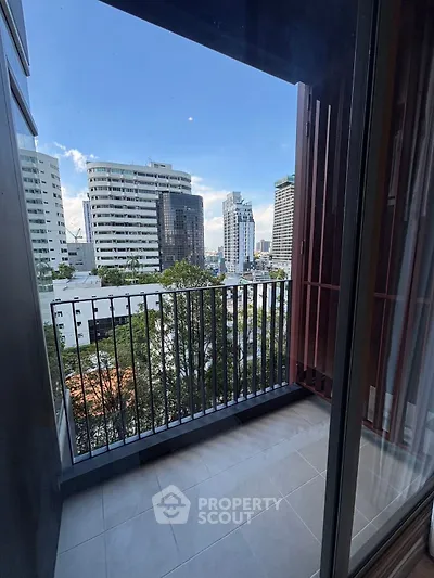 Chic urban balcony with stunning cityscape views in a modern high-rise apartment.