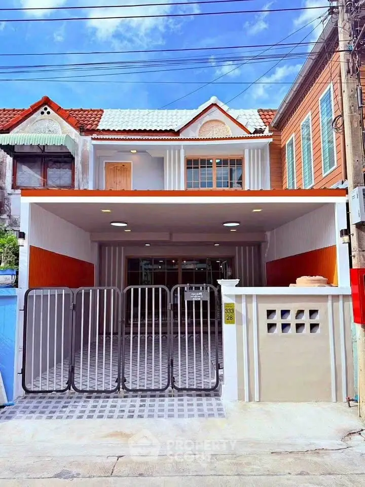 Charming two-story house with modern facade and gated driveway in a vibrant neighborhood.