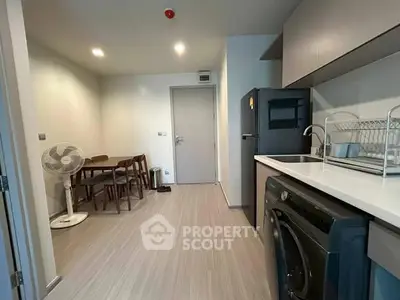 Modern kitchen with sleek appliances and dining area in a cozy apartment