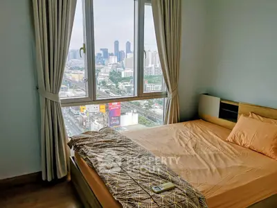 Cozy bedroom with city view, featuring large window and modern decor.