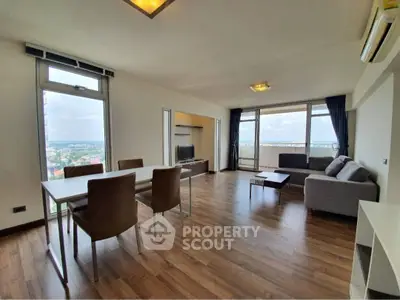 Spacious modern living room with panoramic city view and elegant furnishings.