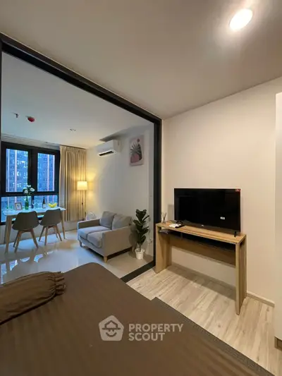 Modern apartment interior with cozy living room and dining area, featuring stylish furniture and natural light.