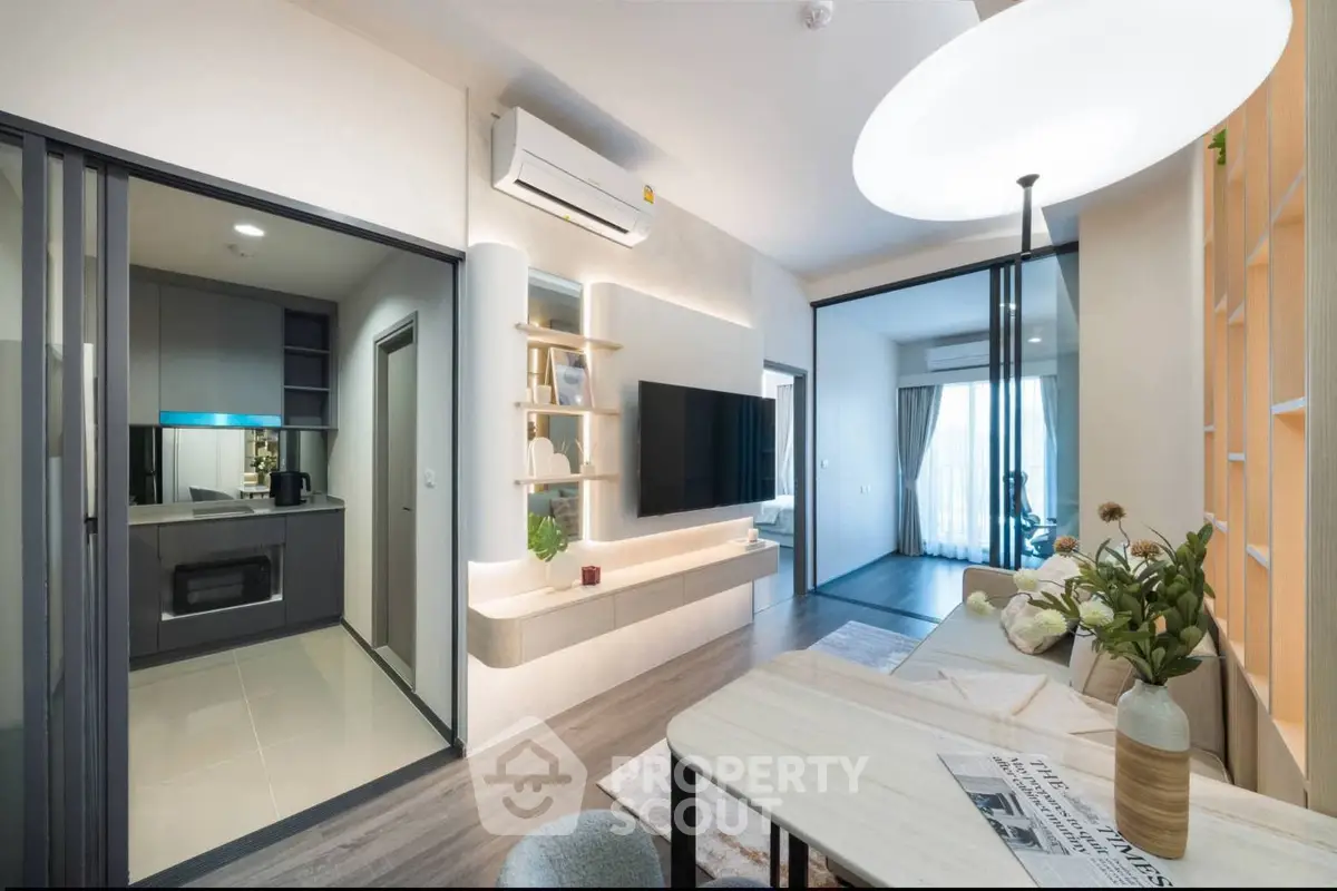 Modern open-plan living room with sleek kitchen and stylish decor in a contemporary apartment.