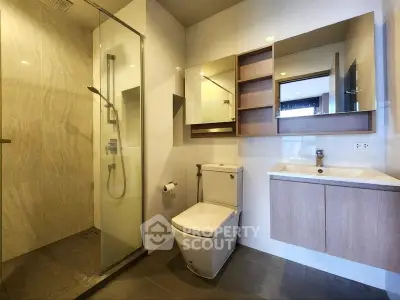 Modern bathroom with glass shower and sleek fixtures in a contemporary apartment.