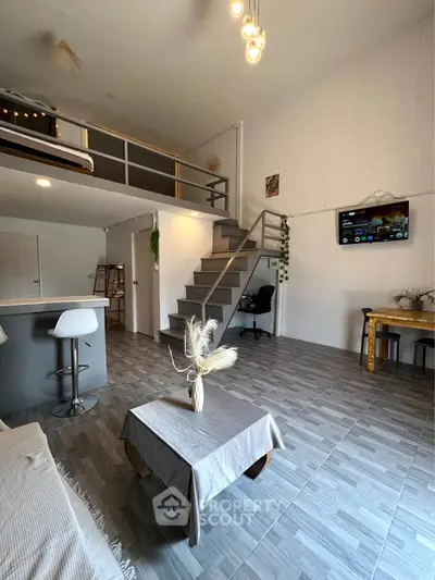 Modern loft apartment with mezzanine, stylish decor, and open living space.