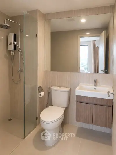 Modern bathroom with glass shower and sleek fixtures in contemporary apartment.
