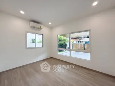 Spacious empty room with large windows and air conditioning, perfect for customization.