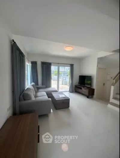 Spacious living room with modern furniture and large windows offering natural light.