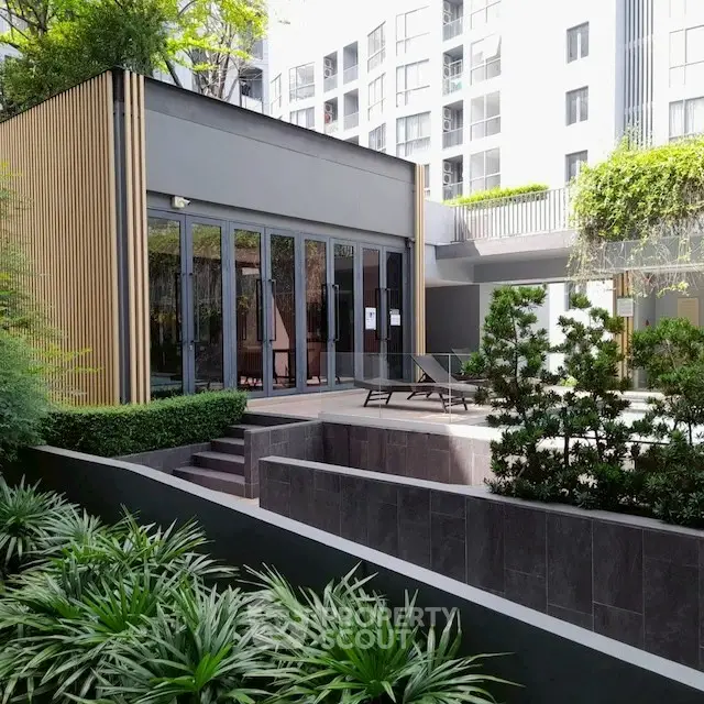 Modern building exterior with lush garden and stylish patio area