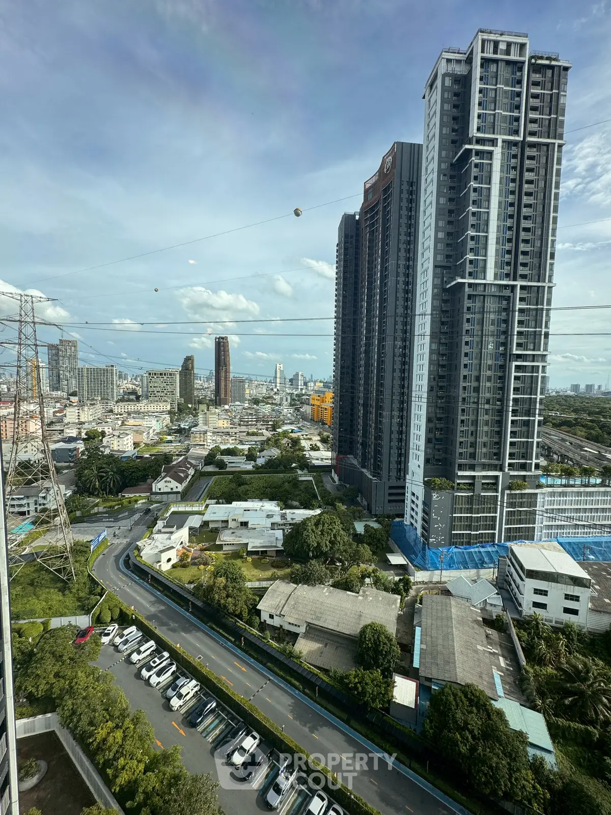Stunning cityscape view from high-rise building with modern architecture and lush greenery.