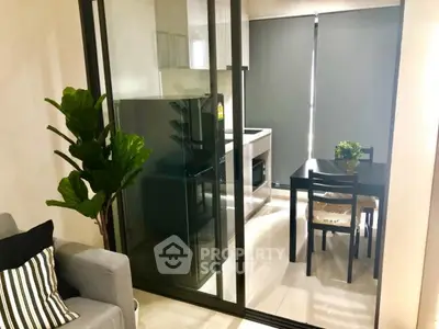 Modern kitchen with glass partition and sleek dining area in a cozy apartment.