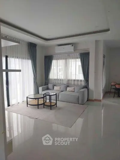 Spacious modern living room with elegant decor and large windows for natural light.
