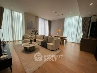 Luxurious open-plan living room with elegant decor and large windows in modern apartment.