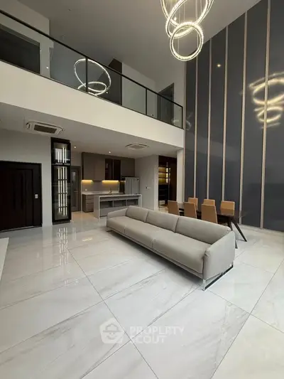 Luxurious modern living room with high ceilings and elegant lighting in a spacious open-plan design.