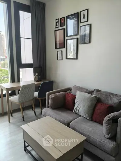 Modern living room with stylish decor and city view, featuring a cozy sofa and elegant wall art.