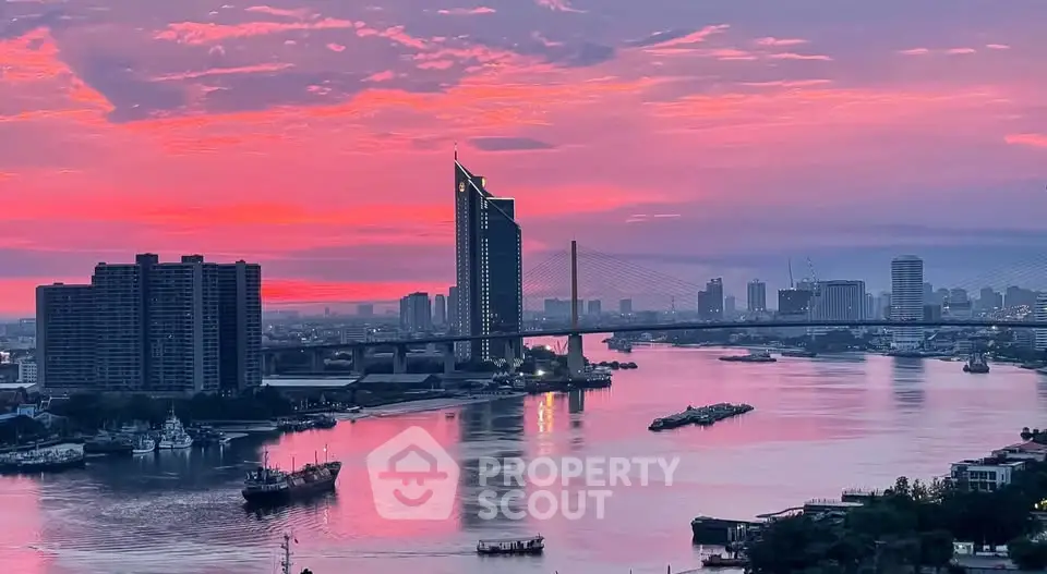Stunning riverfront cityscape with vibrant sunset sky and modern architecture.