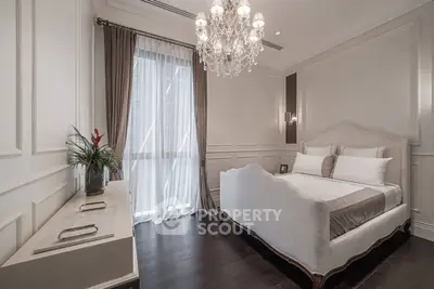 Luxurious bedroom with elegant chandelier and stylish decor in a modern apartment.