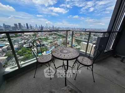 Stunning cityscape view from a high-rise balcony with elegant outdoor seating.