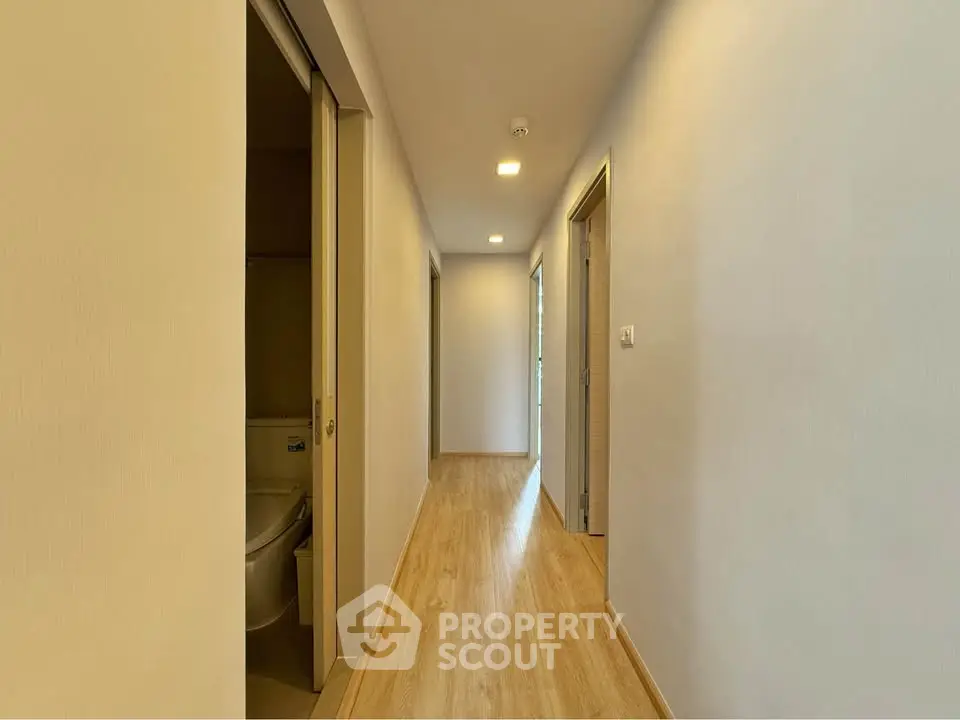 Spacious modern hallway with wooden flooring and soft lighting