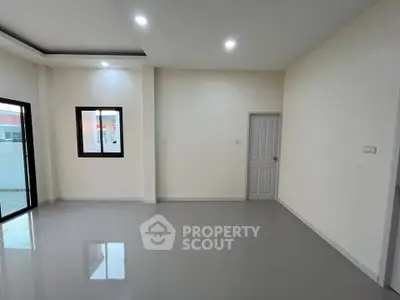 Spacious modern living room with sleek flooring and ample natural light.