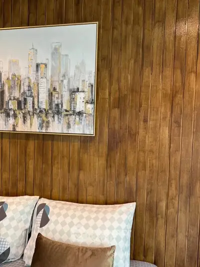 Cozy living room with wood paneling and modern cityscape artwork, perfect for relaxation.