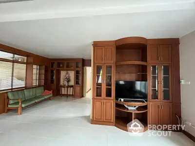 Spacious living room with elegant wooden cabinetry and modern TV setup