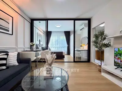 Modern living room with glass partition, stylish decor, and cozy seating area.