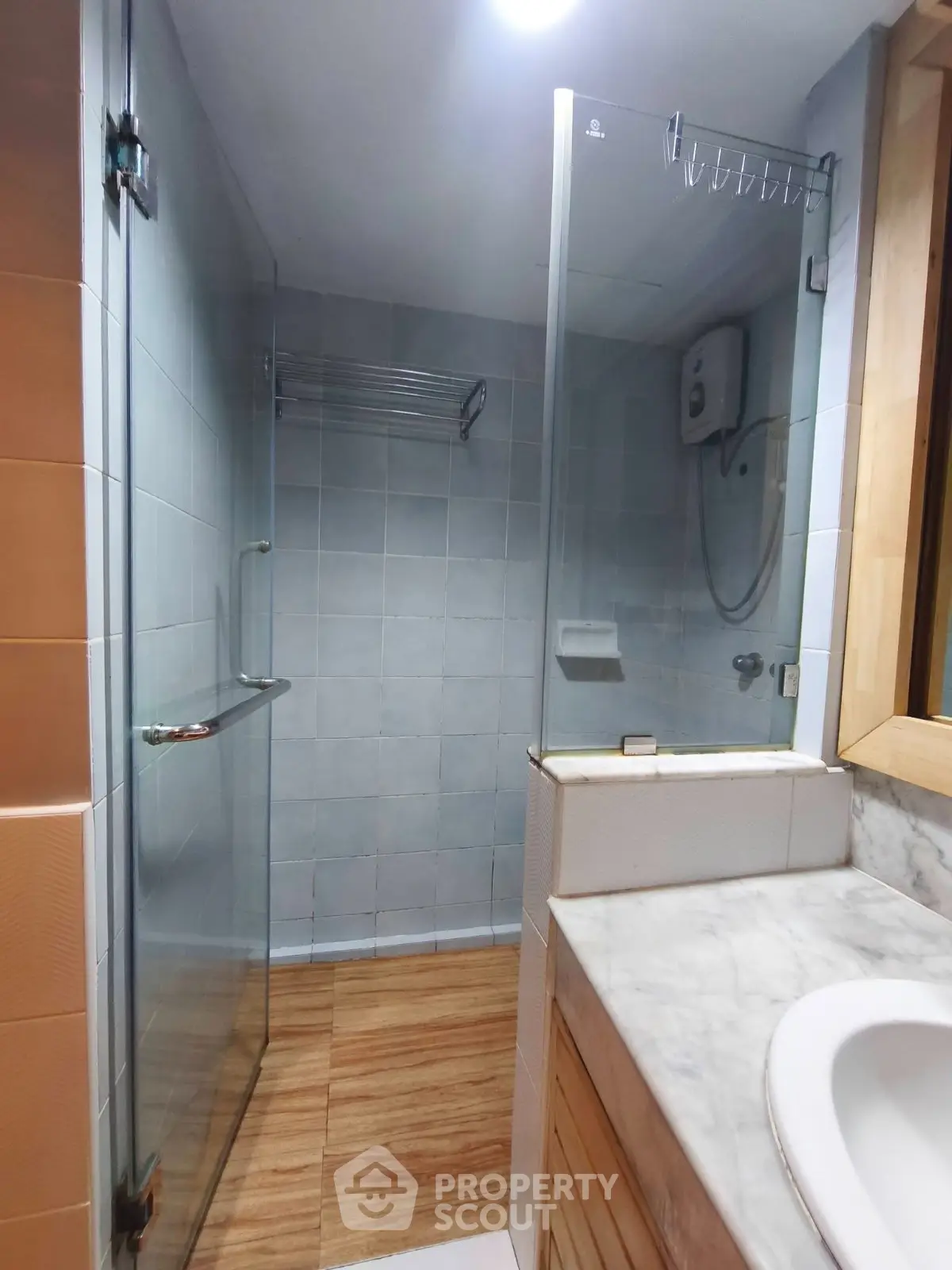 Modern bathroom with glass shower enclosure and marble countertop