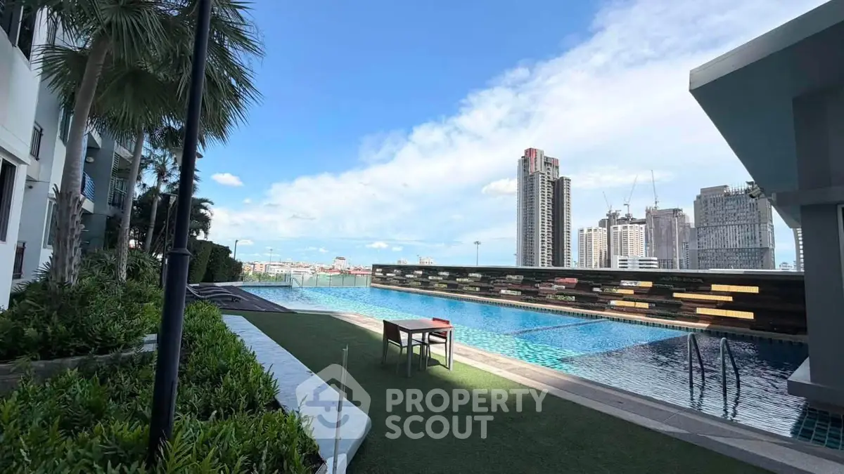 Luxurious rooftop pool with stunning city skyline views and lush greenery.
