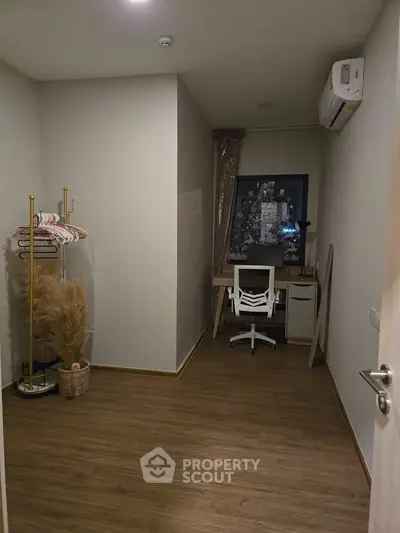 Cozy study room with wooden flooring and modern desk setup, perfect for productivity.