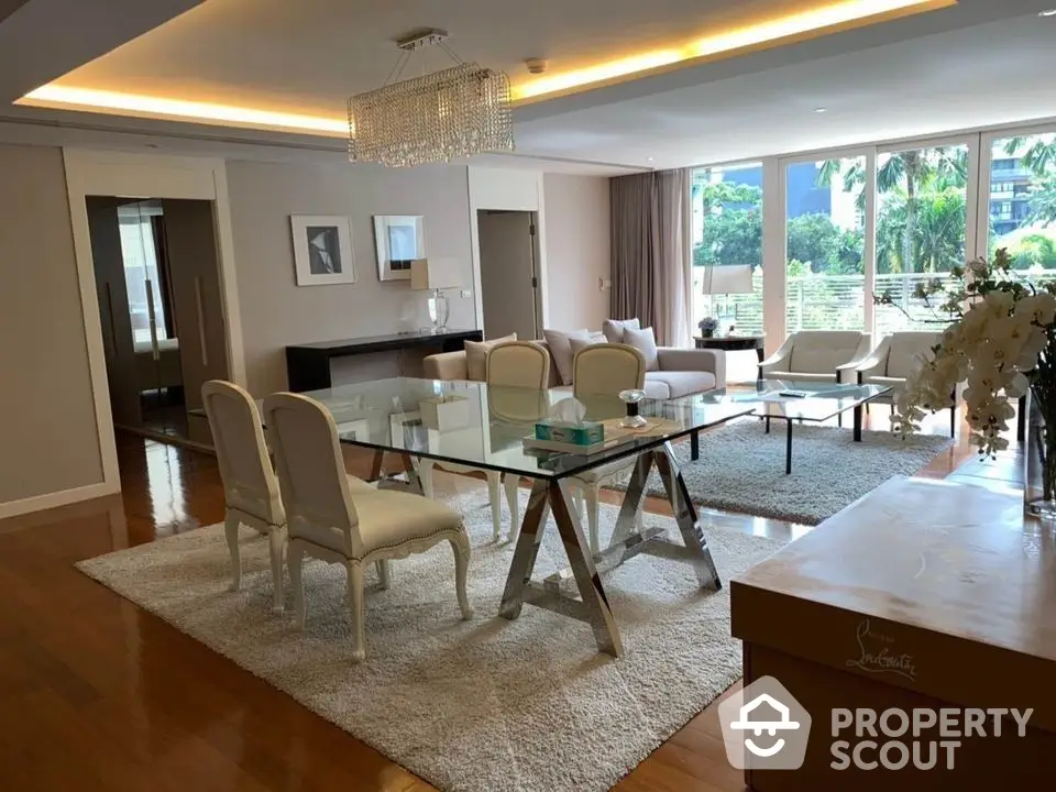 Elegant and spacious living room with modern furnishings, a large dining area, and abundant natural light overlooking lush greenery.