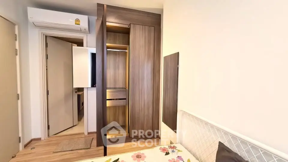 Modern bedroom with built-in wardrobe and air conditioning in a cozy apartment.