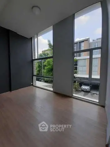 Spacious room with floor-to-ceiling windows offering a bright and airy atmosphere.
