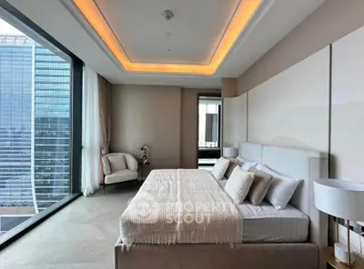 Luxurious bedroom with modern design and stunning city view, featuring elegant furnishings and ambient lighting.