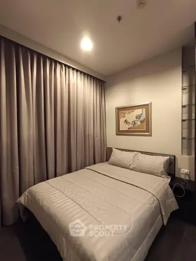 Cozy bedroom with elegant curtains and framed artwork, perfect for relaxation.