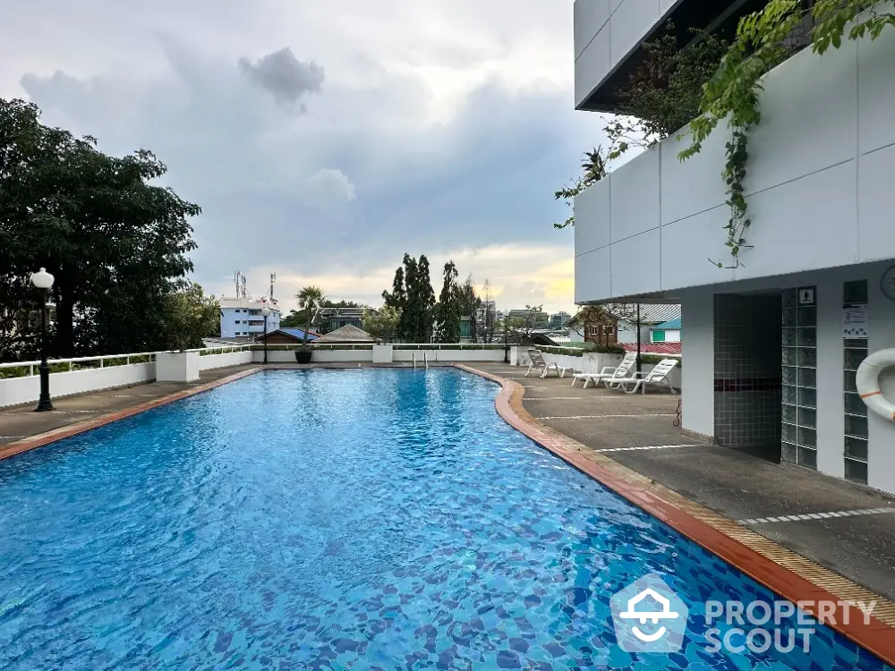 Stunning rooftop pool with city views and lush greenery, perfect for relaxation and leisure.