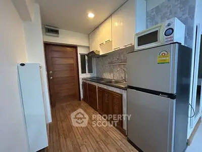 Charming compact kitchen with modern appliances and wooden cabinetry