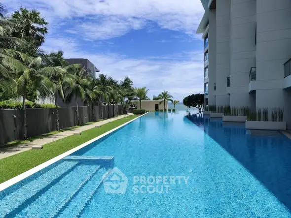 Luxurious residential building with stunning infinity pool and lush palm trees.