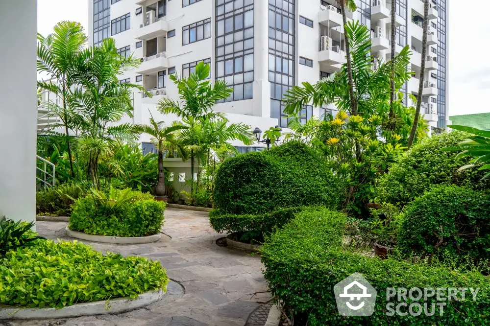 Lush garden view with modern apartment building backdrop