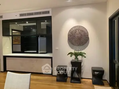 Modern living room with stylish decor and wooden flooring, featuring unique wall art and contemporary furniture.