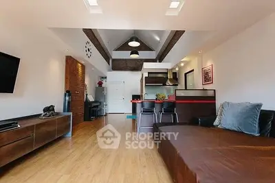 Modern living room with open kitchen, sleek furnishings, and wooden flooring, ideal for contemporary living.