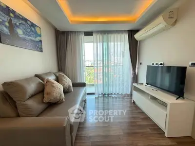 Modern living room with stylish sofa, flat-screen TV, and large window offering natural light and city view.