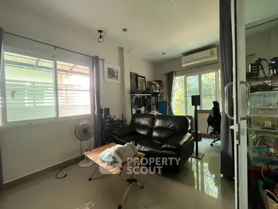 Cozy living room with black leather sofa and natural light