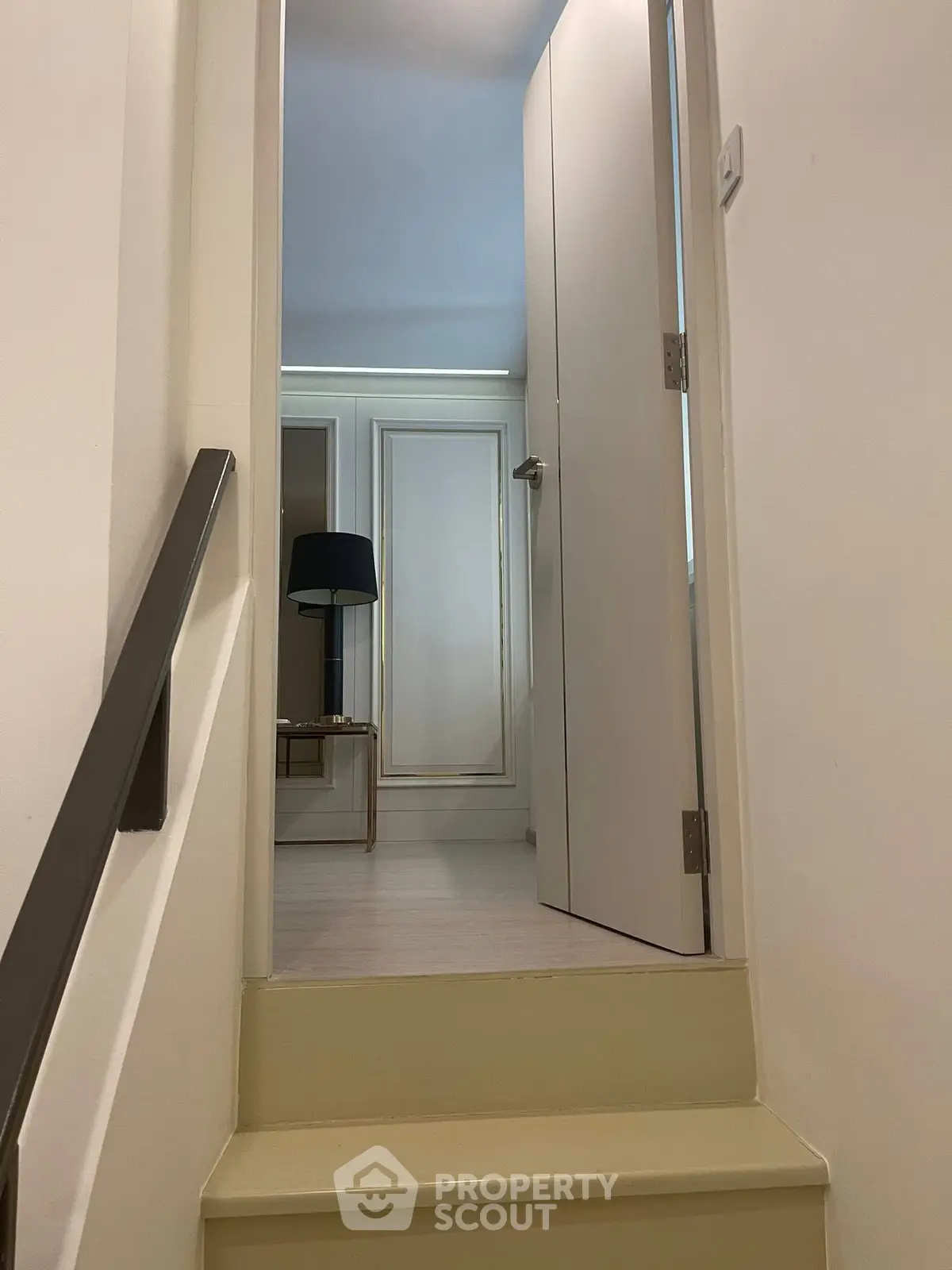 Stylish interior hallway with open door and modern decor, showcasing elegant design and inviting ambiance.