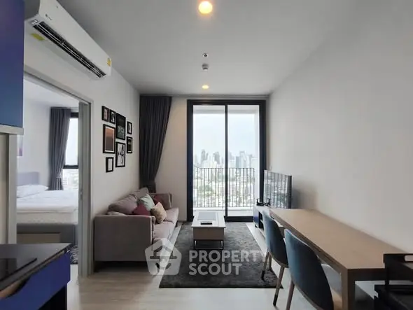 Modern living room with city view, stylish furniture, and large windows in a high-rise apartment.